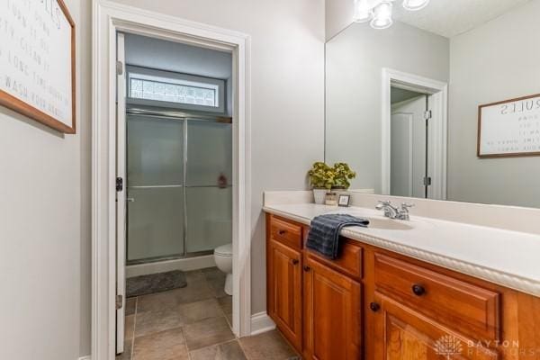 bathroom with vanity, toilet, and a stall shower