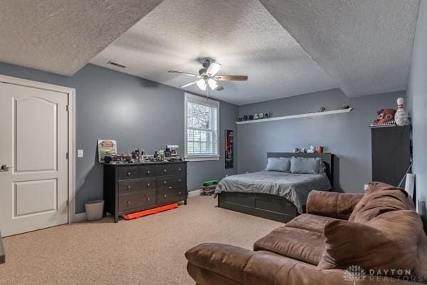 carpeted bedroom with visible vents, baseboards, a textured ceiling, and ceiling fan