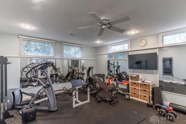 workout room featuring plenty of natural light, a textured ceiling, and a ceiling fan