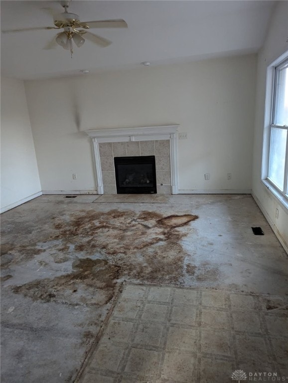 unfurnished living room with a ceiling fan and a fireplace