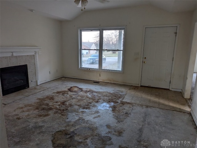 unfurnished living room featuring a ceiling fan, vaulted ceiling, and a fireplace