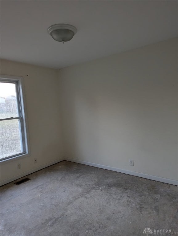 empty room featuring baseboards, visible vents, and concrete floors