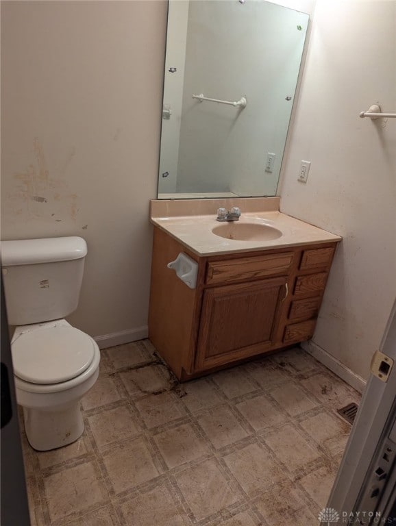 bathroom with tile patterned floors, baseboards, toilet, and vanity