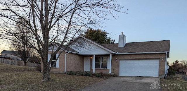 ranch-style house with brick siding, concrete driveway, a garage, and fence