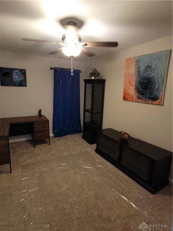 carpeted living area featuring ceiling fan