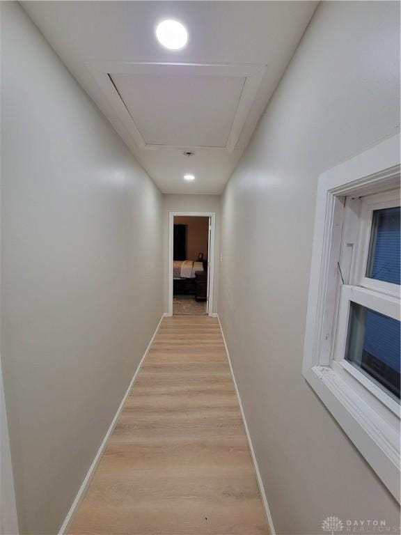 hall with light wood-type flooring and baseboards