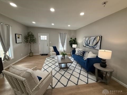 living area featuring recessed lighting, light wood-type flooring, and baseboards