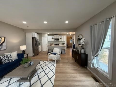 living area featuring light wood finished floors and recessed lighting