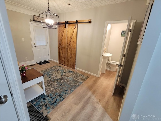 entrance foyer featuring a barn door, baseboards, visible vents, and light wood finished floors