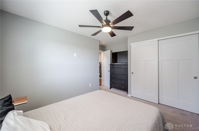 carpeted bedroom with a ceiling fan and a closet