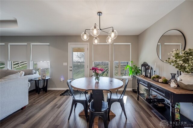 dining space with baseboards, dark wood-style flooring, and a chandelier