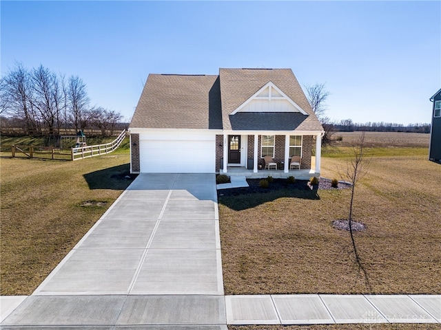 view of front facade with a porch, concrete driveway, brick siding, and a front lawn