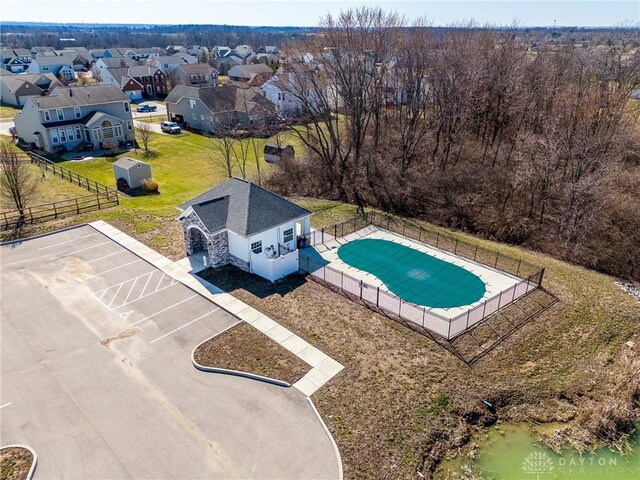 view of swimming pool with an outbuilding, a yard, fence, and a residential view