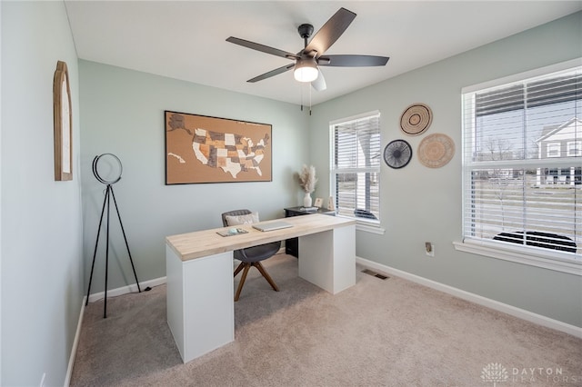 office with visible vents, light carpet, baseboards, and a ceiling fan