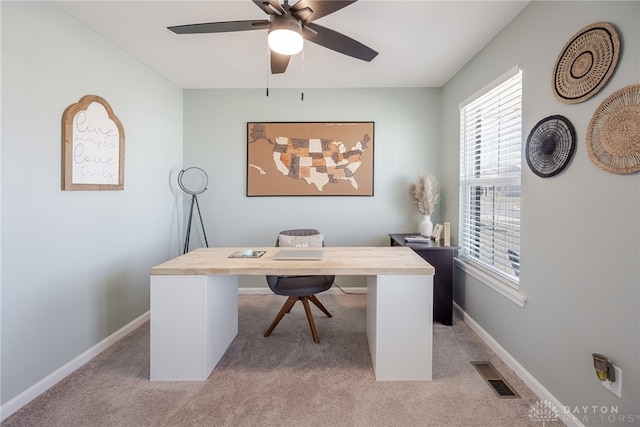 office featuring light carpet, visible vents, ceiling fan, and baseboards