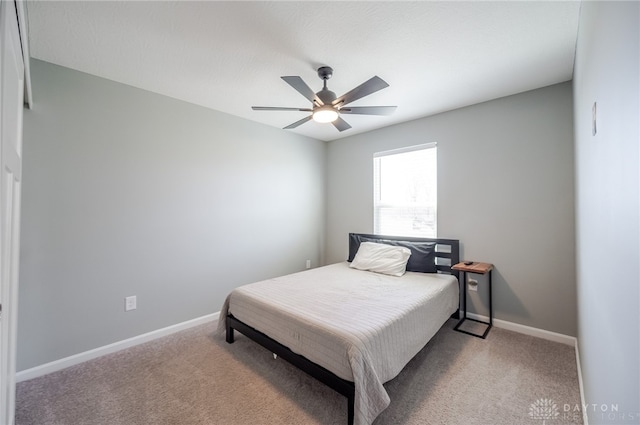 carpeted bedroom featuring baseboards and a ceiling fan