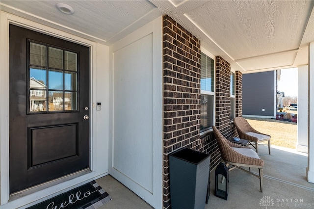 entrance to property with brick siding and covered porch