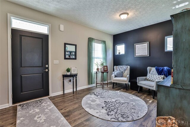 entryway featuring baseboards, a textured ceiling, and wood finished floors