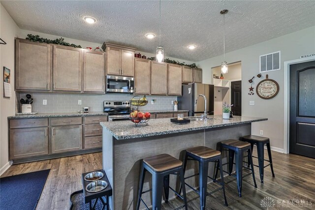 kitchen featuring a sink, dark wood-type flooring, visible vents, and stainless steel appliances