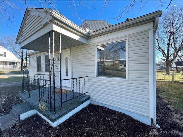 property entrance featuring a porch and fence