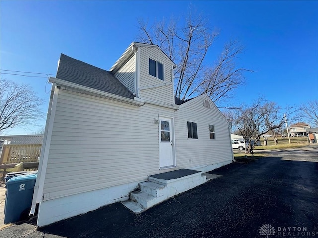 back of house with a shingled roof