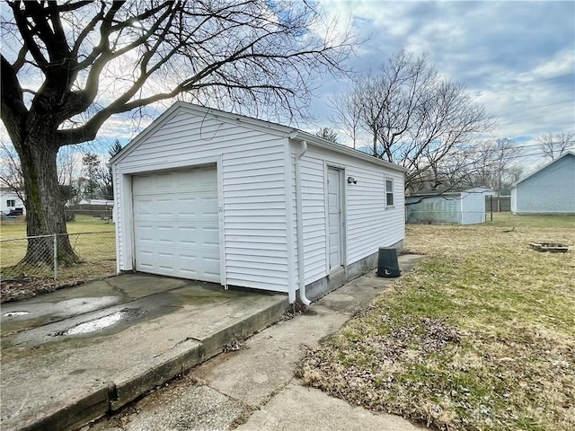 detached garage with driveway and fence