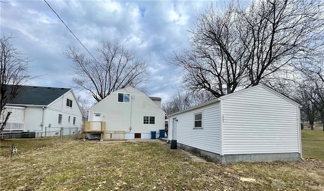 rear view of property with a lawn and fence