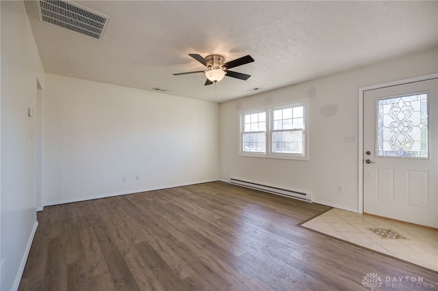 foyer featuring visible vents, baseboard heating, wood finished floors, and a ceiling fan