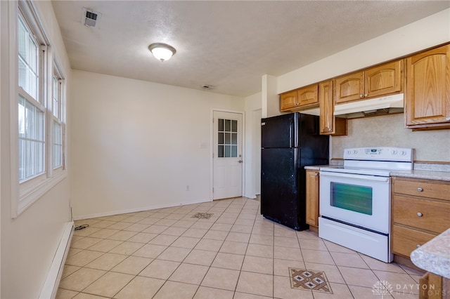 kitchen featuring visible vents, under cabinet range hood, light tile patterned floors, electric stove, and freestanding refrigerator