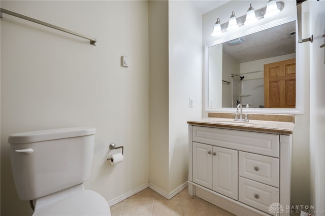 bathroom featuring tile patterned floors, toilet, vanity, and baseboards