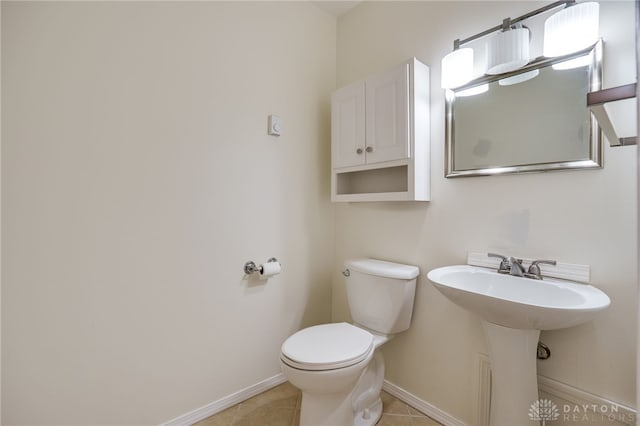 bathroom with tile patterned flooring, toilet, and baseboards