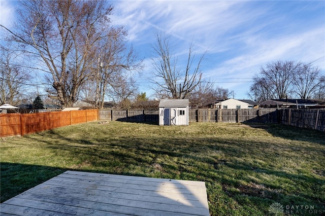 view of yard with a storage shed, an outdoor structure, a deck, and a fenced backyard