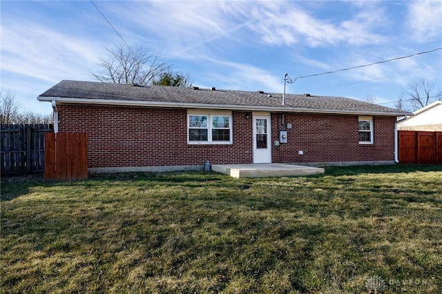 back of house with a patio area, a yard, fence, and brick siding