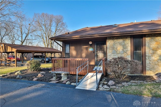 view of front of property featuring stone siding and a detached carport