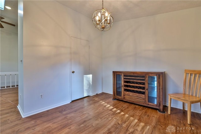 interior space with an inviting chandelier, wood finished floors, and baseboards