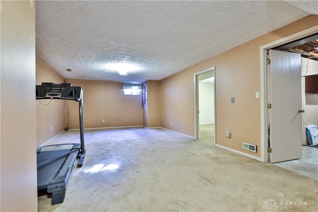 workout room featuring carpet flooring, baseboards, visible vents, and a textured ceiling