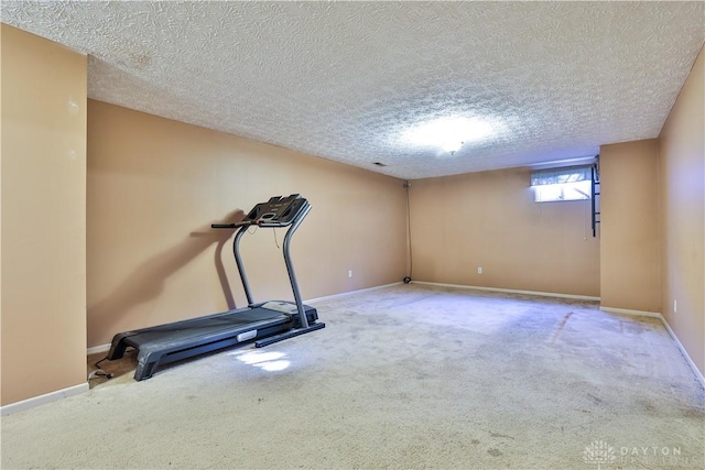 workout area with carpet, baseboards, and a textured ceiling