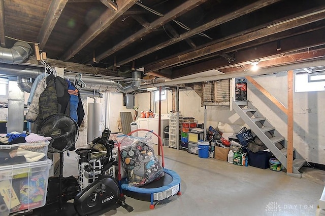 basement featuring electric panel, washing machine and dryer, gas water heater, and stairway