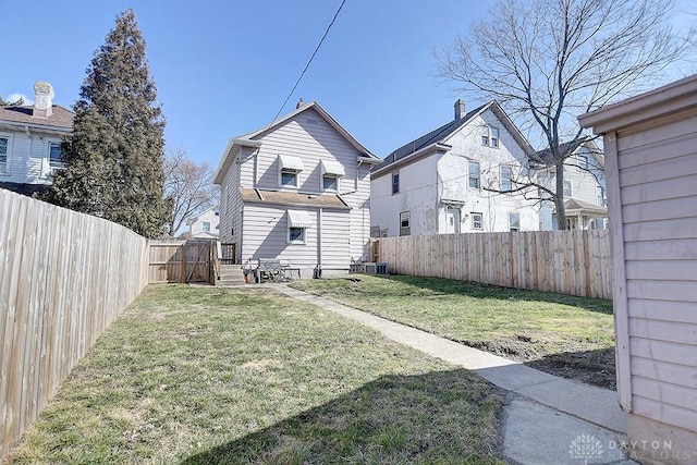 rear view of property featuring a lawn, a residential view, and a fenced backyard