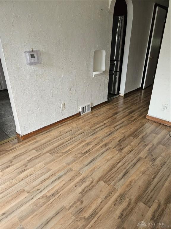 25 Redwood Ave, Dayton, OH 45405 - unfurnished room featuring visible vents, arched walkways, wood finished floors, baseboards, and a textured wall