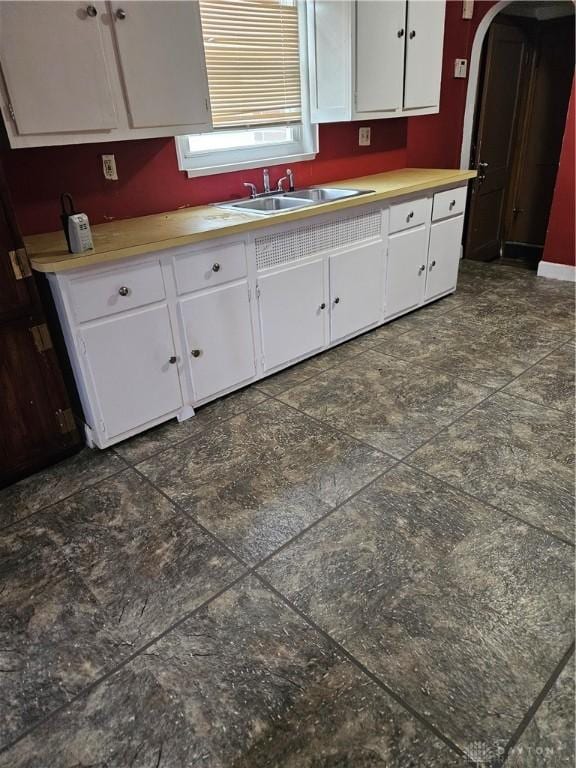 25 Redwood Ave, Dayton, OH 45405 - kitchen featuring a sink, arched walkways, white cabinetry, and light countertops