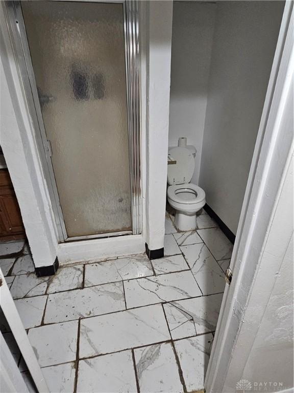 25 Redwood Ave, Dayton, OH 45405 - full bathroom with toilet, baseboards, marble finish floor, and a stall shower