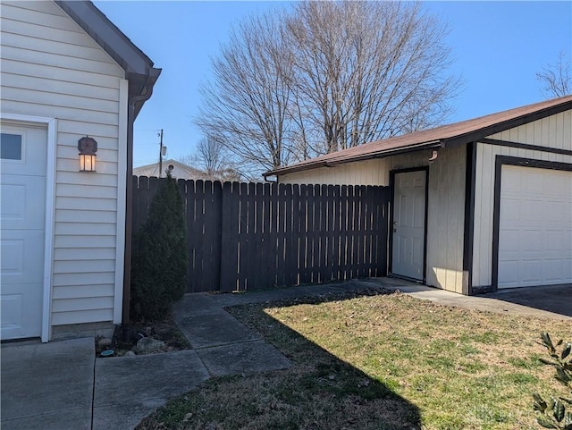 view of yard featuring an outdoor structure, a garage, and fence