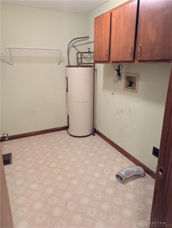 washroom featuring water heater, visible vents, cabinet space, and baseboards