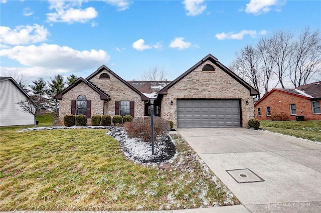 view of front of property with a front lawn, a garage, brick siding, and driveway