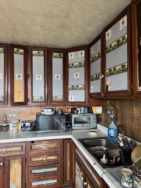 kitchen featuring a textured ceiling, light countertops, and a sink