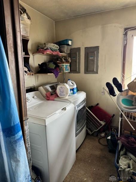 laundry area featuring laundry area, electric panel, and washing machine and clothes dryer