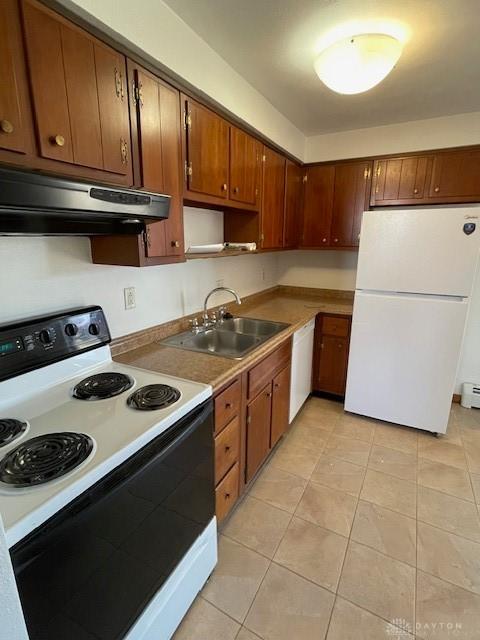 kitchen with under cabinet range hood, a baseboard heating unit, a sink, white appliances, and light tile patterned floors