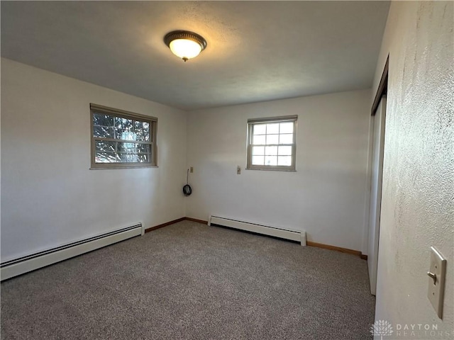 carpeted empty room with a baseboard radiator, baseboards, and baseboard heating