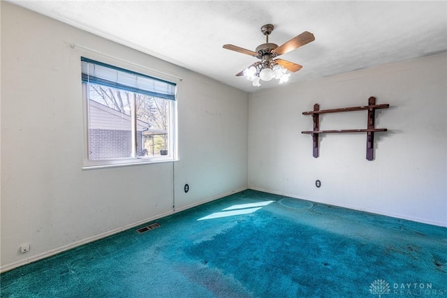 unfurnished room with carpet, baseboards, visible vents, ceiling fan, and a textured ceiling